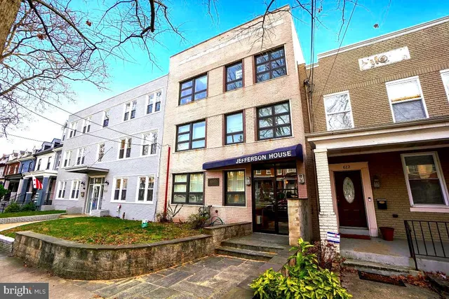 a front view of a brick building with a small yard