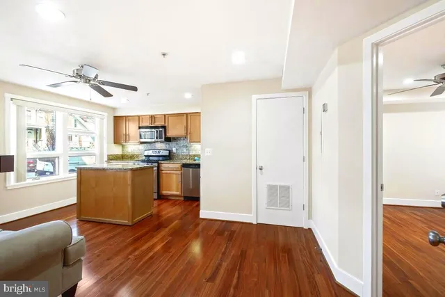 a kitchen with wooden floors and stainless steel appliances
