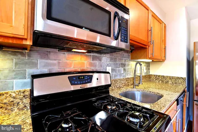 a kitchen with a stove a sink and a microwave