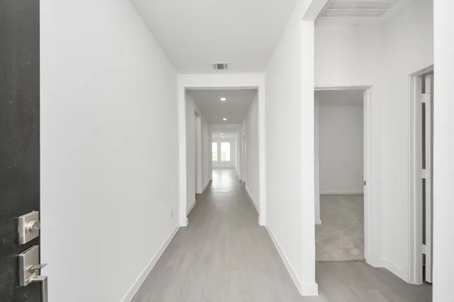a view of a hallway with wooden floor