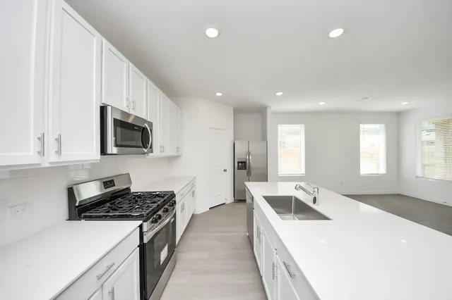 a view of a kitchen that shows a sink and dishwasher with wooden floor