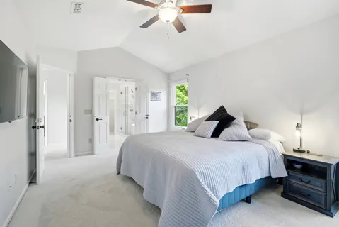 a bedroom with a bed and a flat tv screen on dresser