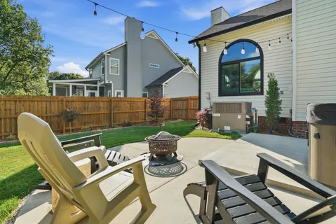a patio with wooden floor a yard a table and chairs