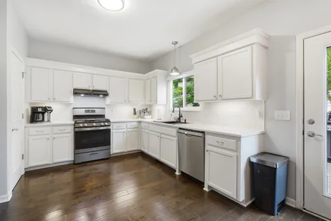 a kitchen with a refrigerator a stove top oven a sink and cabinets
