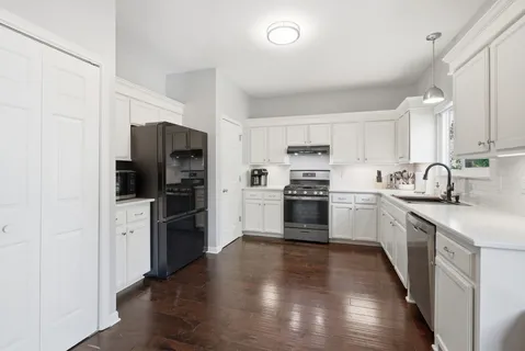 a kitchen with sink cabinets and wooden floor