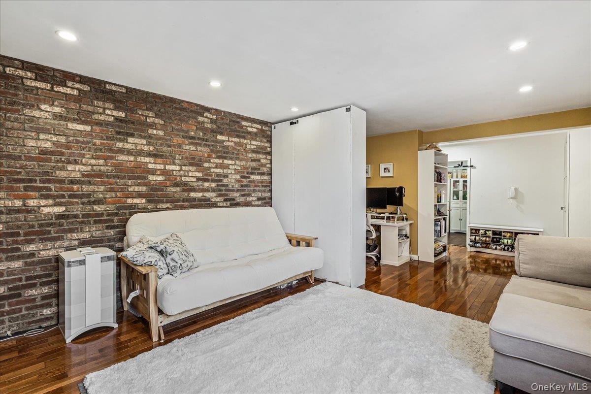 144-55 Melbourne Avenue, Unit 6E Queens, NY 11367 - Photo 9 of 24 Living area featuring dark wood-style floors, brick wall, recessed lighting, and an office area