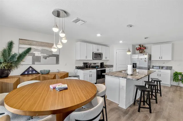 a living room with furniture kitchen view and a large window