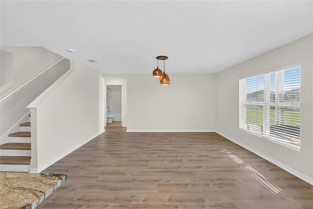 an empty room with a ceiling fan and window
