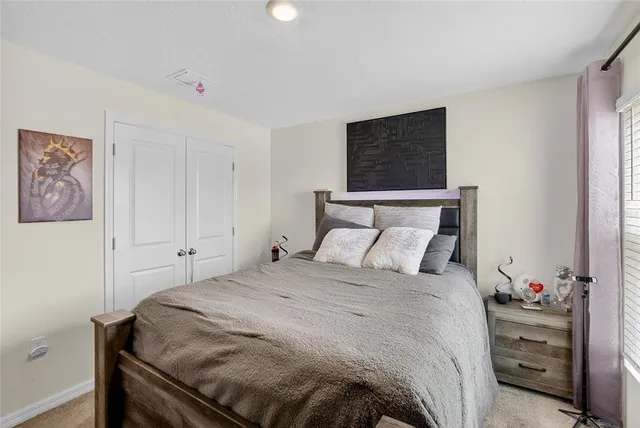 a spacious bedroom with a bed a mirror and furniture