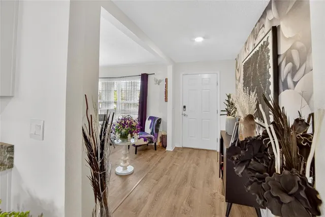 a kitchen with stainless steel appliances kitchen island granite countertop a table chairs cabinets and wooden floor