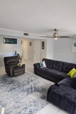 a living room with furniture and a ceiling fan