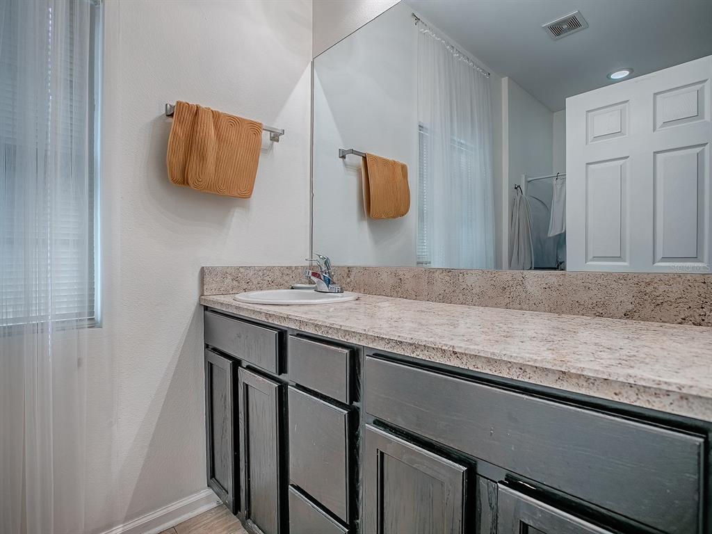 7840 Northwest 21 Way Gainesville, FL 32609 - Photo 19 of 38 a bathroom with a granite countertop sink and a mirror