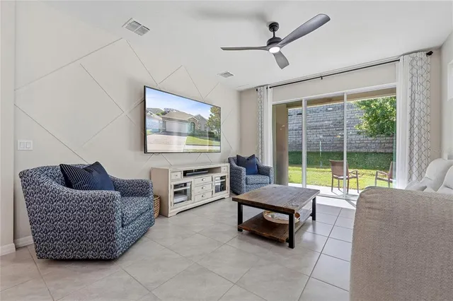 a living room with furniture and a floor to ceiling window