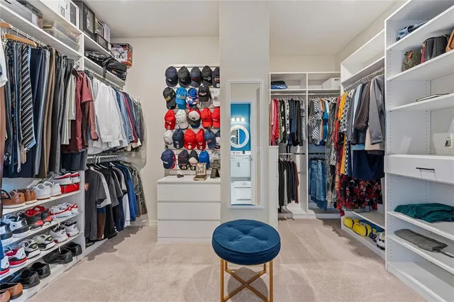 a view of walk in closet with clothes and shoes