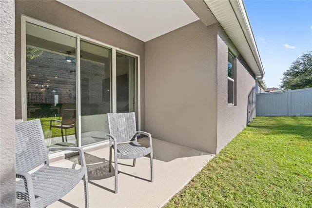 a balcony with chairs and potted plants