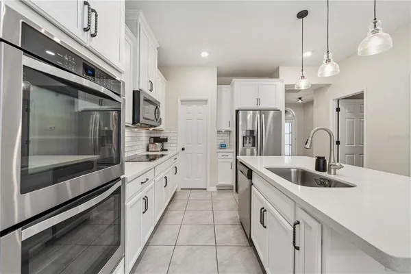 a large kitchen with granite countertop a sink and stainless steel appliances