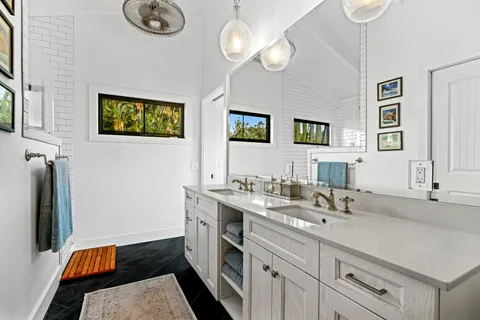 a bathroom with double vanity sink and a mirror