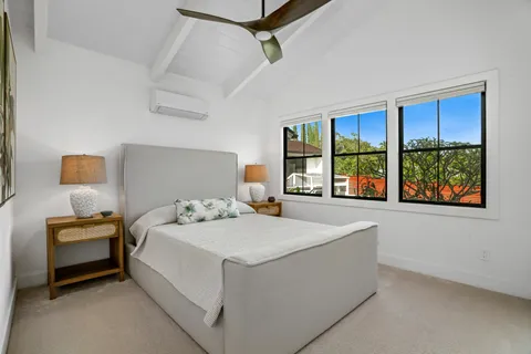 a bedroom with a bed and a large window