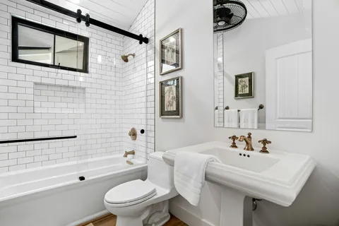 a bathroom with a sink a toilet and shower