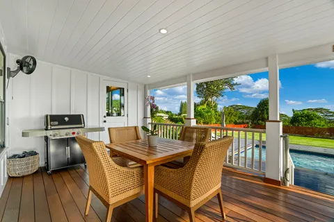 a dining room with furniture a floor to ceiling window and wooden floor