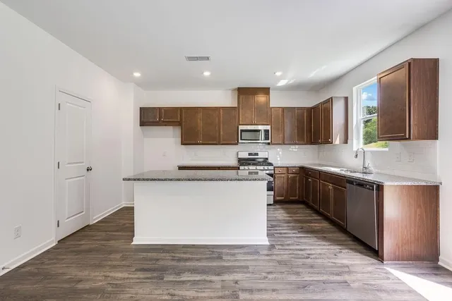 a large kitchen with stainless steel appliances and a sink