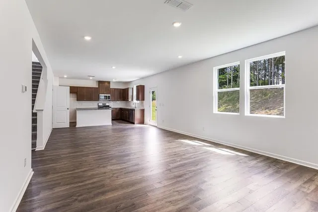 a view of open kitchen with kitchen island wooden floors and stainless steel appliances