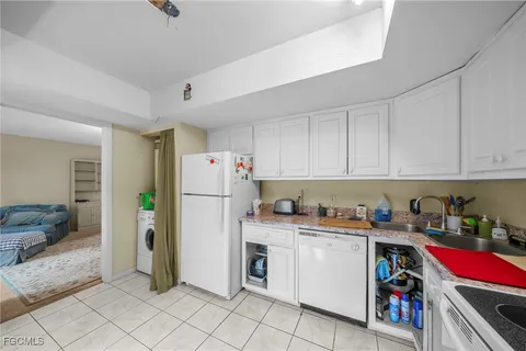 a kitchen with a refrigerator and white cabinets