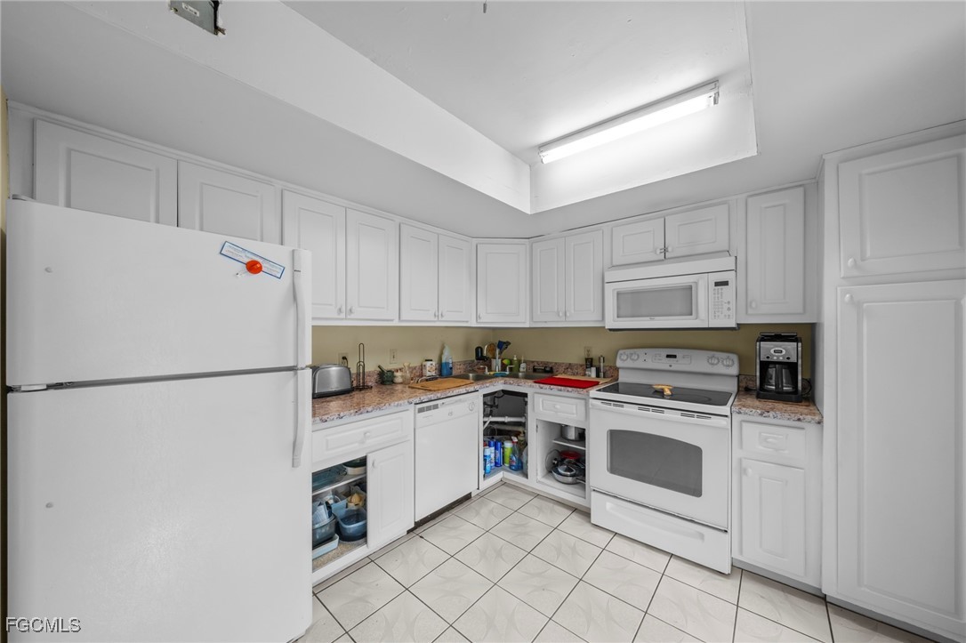 202 Bobolink Way, Unit 202B Naples, FL 34105 - Photo 15 of 31 a kitchen with white cabinets and white appliances