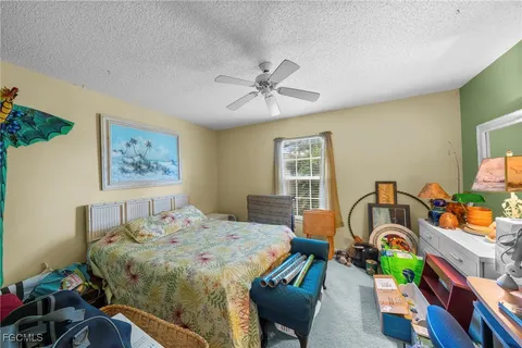 a bed sitting in a bedroom next to a window with workspace