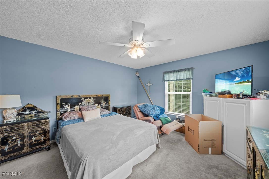 202 Bobolink Way, Unit 202B Naples, FL 34105 - Photo 20 of 31 a bedroom with a bed and a chandelier