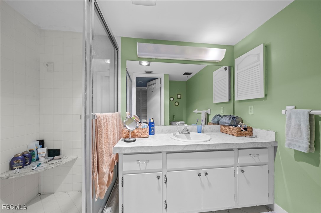 202 Bobolink Way, Unit 202B Naples, FL 34105 - Photo 22 of 31 a bathroom with a sink and a mirror