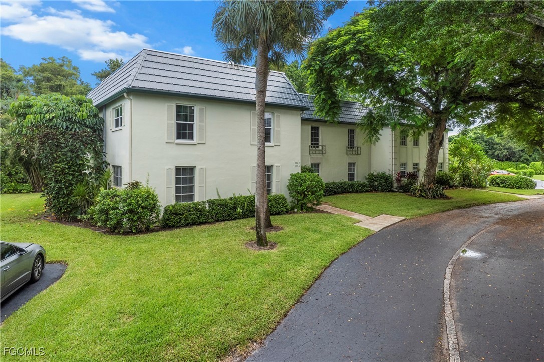 202 Bobolink Way, Unit 202B Naples, FL 34105 - Photo 3 of 31 a front view of a house with garden