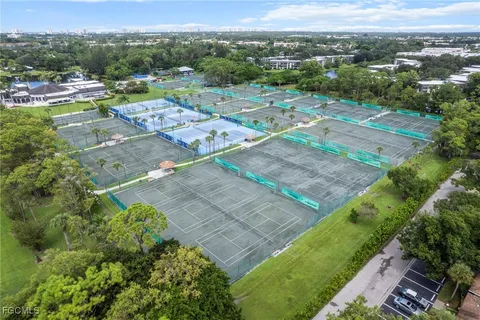 an aerial view of a residential houses with outdoor space and trees