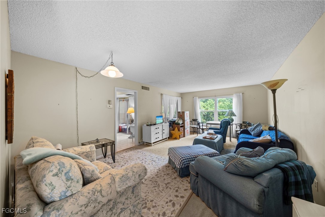 202 Bobolink Way, Unit 202B Naples, FL 34105 - Photo 8 of 31 a living room with furniture and a large window