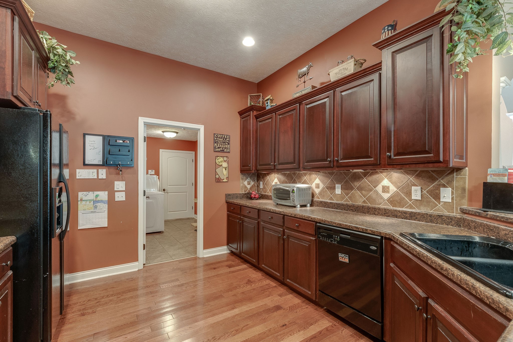 1112 Pee Dee Branch Road Cottontown, TN 37048 - Photo 16 of 33 a kitchen with stainless steel appliances granite countertop a refrigerator a sink dishwasher and wooden cabinets with wooden floor