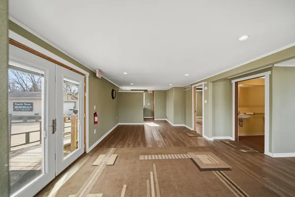 a view of an empty room with window and wooden floor
