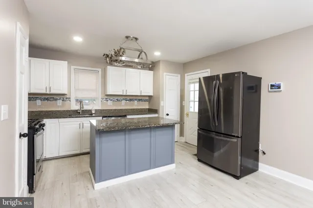 a kitchen with granite countertop a refrigerator and a sink
