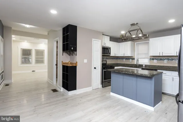 a kitchen with stainless steel appliances granite countertop a refrigerator and a stove top oven