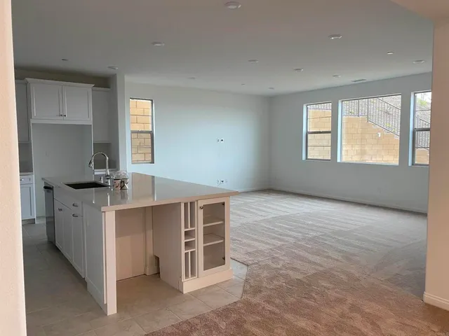 a view of kitchen with stainless steel appliances granite countertop a stove a sink and a refrigerator