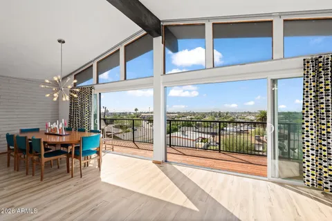 a view of a porch with chairs and floor to ceiling window