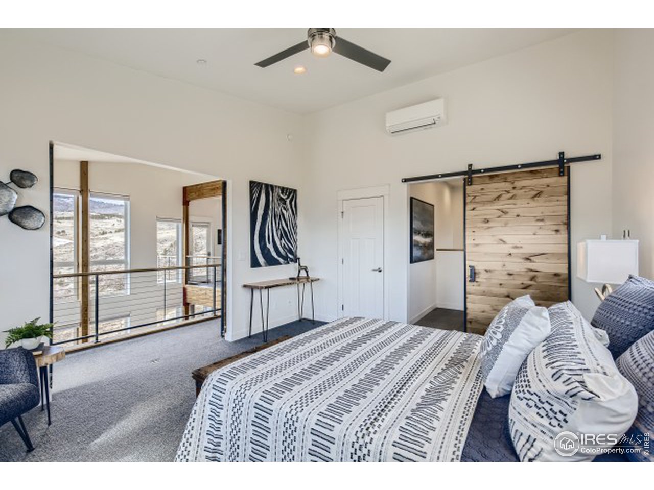 1133 Arroyo Chico Road Boulder, CO 80302 - Photo 19 of 37 a bedroom with a large bed and a chandelier
