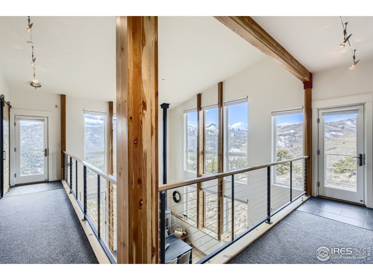 1133 Arroyo Chico Road Boulder, CO 80302 - Photo 24 of 37 a view of a hallway with wooden floor and staircase