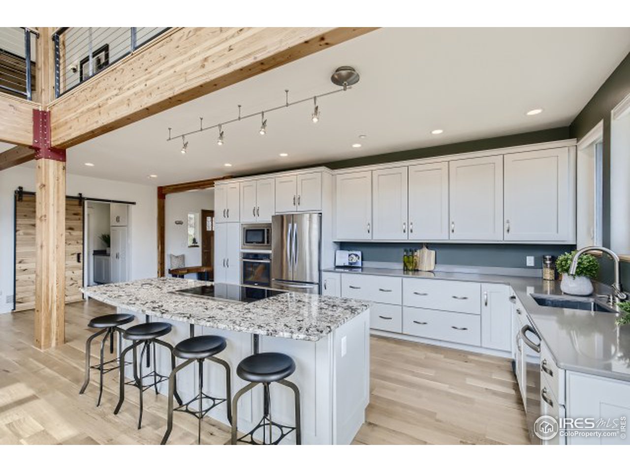 1133 Arroyo Chico Road Boulder, CO 80302 - Photo 10 of 37 a kitchen with stainless steel appliances kitchen island granite countertop a table chairs sink and cabinets