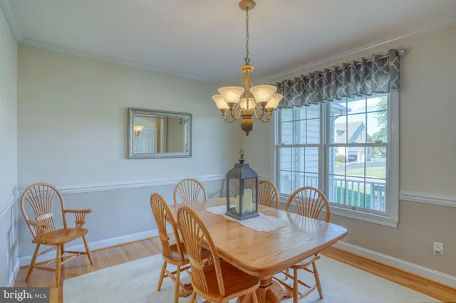a dining room with furniture a chandelier and wooden floor