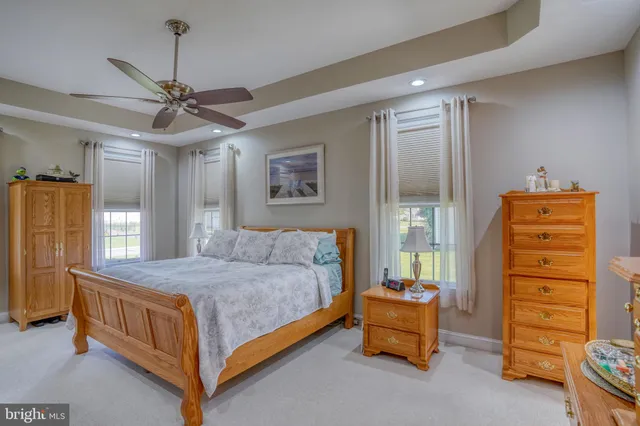 a spacious bedroom with a bed and a dresser