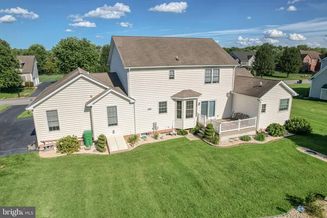 a view of a white house with a yard table and chairs