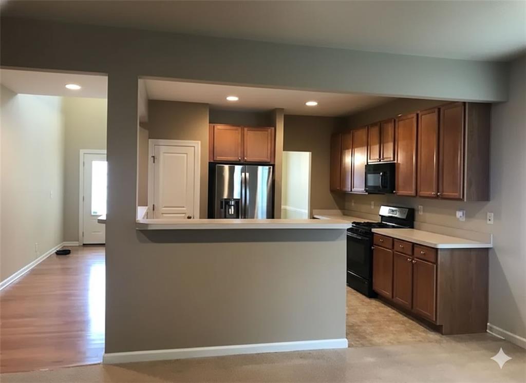 7923 Keepsake Lane Flowery Branch, GA 30542 - Photo 3 of 6 a large kitchen with stainless steel appliances wooden floor and large window