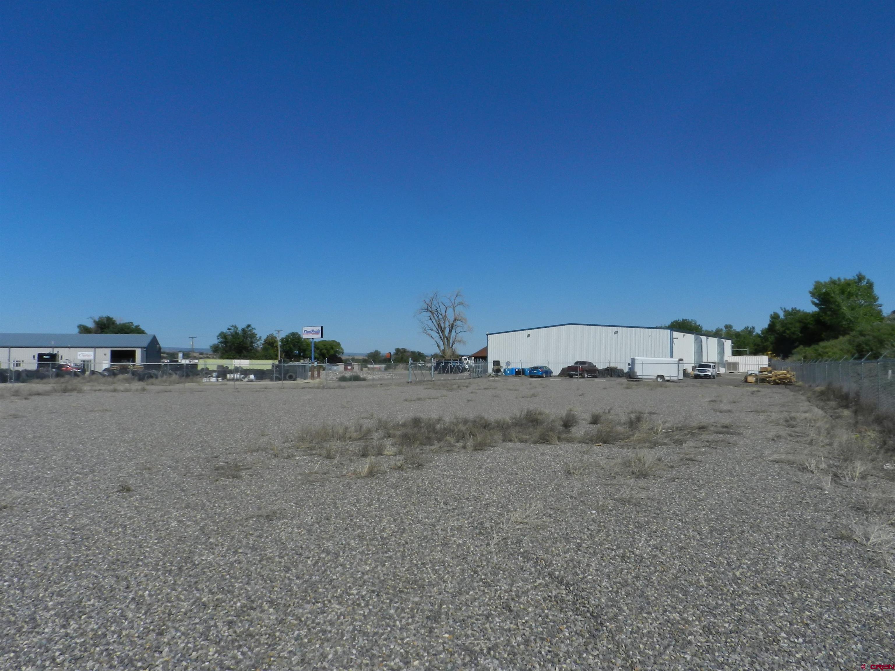 Tbd 6225th Road, Unit LOT LEASE Montrose, CO 81401 - Photo 5 of 14 a view of a dry field with trees in the background