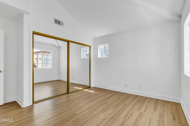 an empty room with wooden floor and door