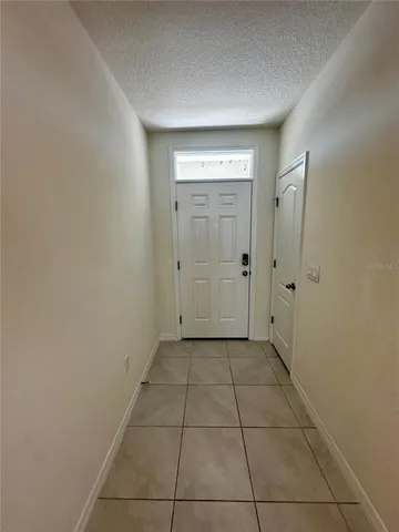a view of a hallway with wooden floor and a bathroom